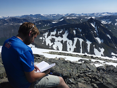 Kroksleiven studerar gjesteboka - ikkje så mange som er opp her samanlikna med naboane. Neste turmålet, Tverrfjellet, i bakgrunnen.