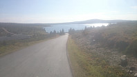 Flott utsikt mot Reinsvatnet da jeg setter utfor den asfalterte bakken ned mot bekken, og da er det flott grusvei tilbake til Nordseter. Nevelfjell i bakgrunnen