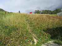 Rød pil der stien tok av bak en låve