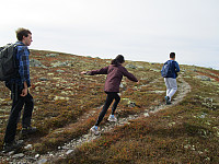 Vi tok av en liten sti mot nordsiden av toppen for å komme i le av vinden