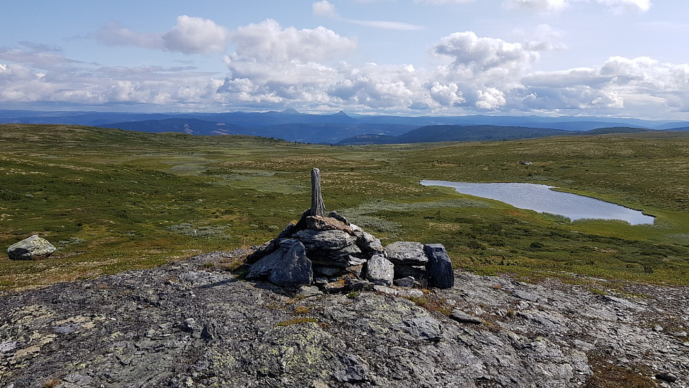 Da var jeg på det høyeste punktetr som var litt mindre markert enn den første toppen. Mellene i det fjerne på hver sin side av den stående steinen i varden