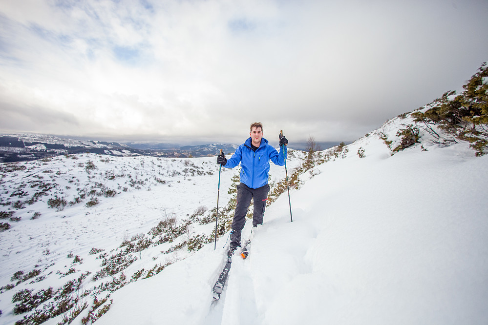 Raymond på vei opp Stangfjellet på fjellski. Mye busker i bratt terreng