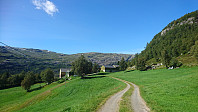 Tror at stien går rett over innmark mot port til høyre for gården. (Jeg rota meg rett gjennom tunet).
