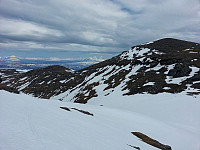 På vei oppover de siste bakkene mot toppen. Ser tilbake mot den nesten snøfrie solskråningen på Hjerttindtuva.