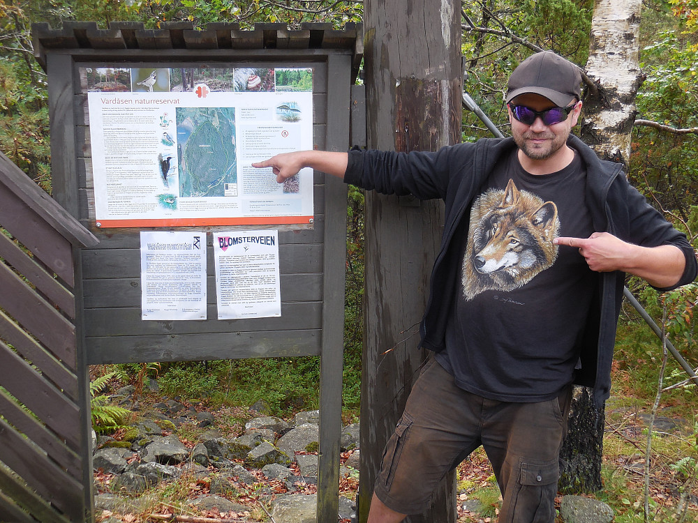En ekte villmarking poserer på toppen, 88 moh. sammen med infotavla til Vardåsen naturreservat.