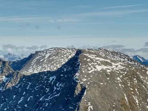 Sørtoppen av Trollvasstinden (1422 m.o.h.) omtrent midt i bildet, og med fjellryggen som fører mot midt-toppen (litt utenfor venstre billedkant). Bak sees deler av Litlevasstinden, og i det fjerne sees Trolltindan i Rauma med bl.a. Trollryggen, Bruraskaret og Store Trolltinden.