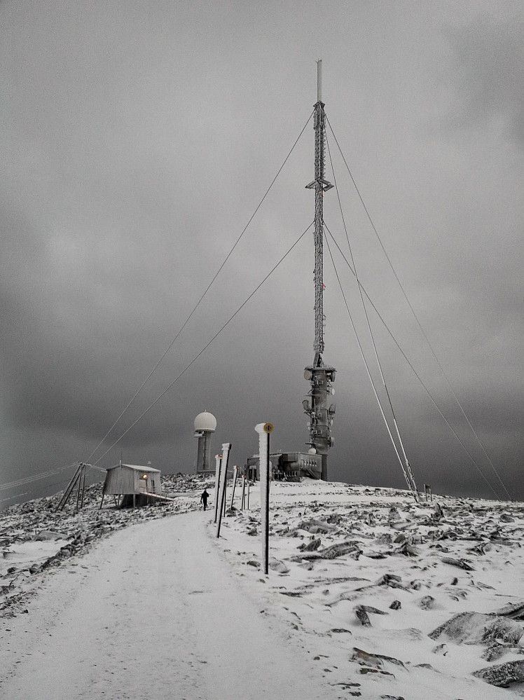 The summit of Mount Gamlemsveten with the TV antenna and telecommunications equipment. There was not much snow on the ground due to wind that had been blowing it away, but you can se snow attached to the roadsigns.
