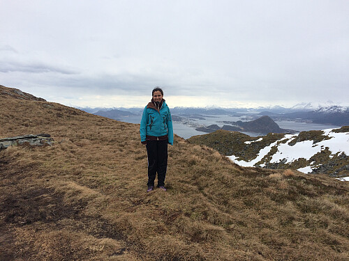 Sol standing in the "saddle" between the two summits of Mount Storhornet. Behind her the town of Ålesund is seen.