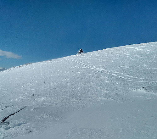 #18: A stone visible through the snow at the summit of Mount Kvasstind. Only where the stones were protruding through the snow, did I dare to approach the edge of the mountain; elsewhere I kept quite a distance between myself and the edge, knowing that the ice shelves may break off, sending you right into the abyss beneath.