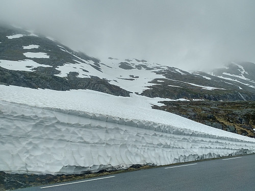 #1: I'ts 1. of July, and the amount of snow has been decreasing lately, but it was still possible to put your skis on already by the roadside, and then go skiing all the way up to the summit of Mount Alnestind without taking your skis off. The weather, however, was quite cloudy, even from startout; and as I got higher up, it even started snowing.