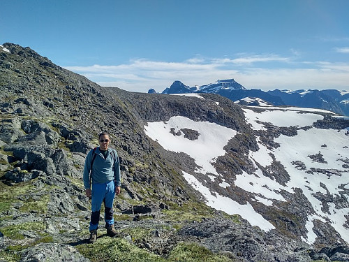 Image #15: On the top ridge of Mount Setnestinden. Here my son Dag is standing on the northern peak, and the summit is seen behind him. The two highest mountains visible in the background is Mount Kongen [i.e.: "The King"] (left) and Mount Finnan (right).