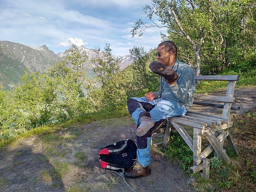 Image #18: Emptying the shoes of some debris while admiring the marvelous view at Nuken Viewpoint.