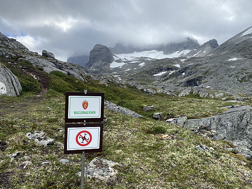 Image #6: Shortly before reaching the top of Mount Norafjellet, you enter into a National Park. The lower sign tells you that the use of drones is prohibited in the park. Note the Adelsbreen Glacier in between two mountain ridges in the background.
