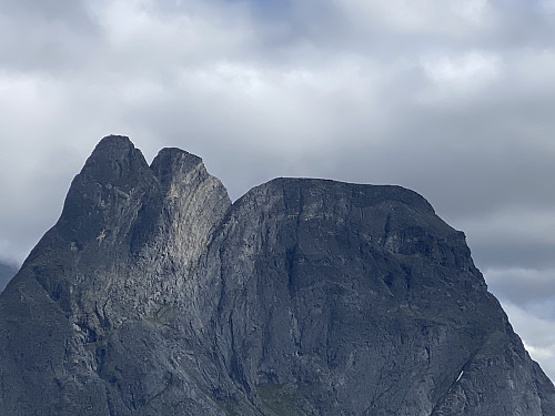 Image #11: A closer view of Mount Romsdalshornet, revealing people on top of it. This mountain is challenging to climb, and was first summited around 1828.