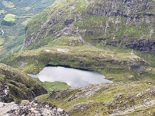 Image #17: View back down at Lake Svartebottsvatnet from atop a chute that separates the southeast ridge of the mountain from another ridge, that goes more directly southwards. The valley of Isterdalen is seen in the background to the left, and the steep north face of Mount Haugabotstinden is seen to the right.
