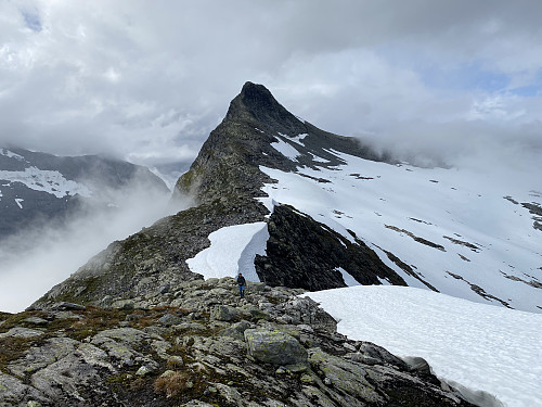 Image #20: Looking back at Mount Honndalsrokken from the ridge up to the top of Mount Sætrenibba. By now, there were no longer any clouds covering the summit of the mountain, but there were still clouds in the valley beneath. The snow/ice shelf that I considered a bit dangerous to cross (see text), is the one visible just behind my son.