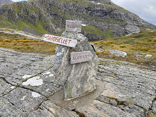 Image #4: A trail sign on the tiny ridge between Lake Kleivavatnet and Rypdalen Valley. Part of the lake may be spotted behind the stone with the signs.