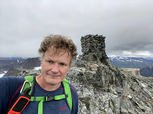 Image #10: On top of the mountain. Behind me is the cairn on the summit, and a little cabin where it's possible to seek shelter from wind and rain etc.