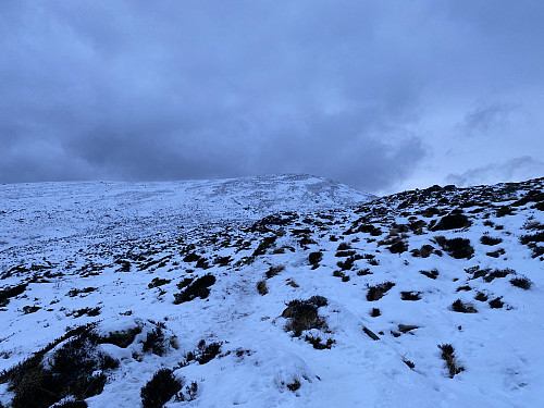 Image #1: The partially snow-covered landscape with the trail towards the peaks of Rundehornet and Tverrfjellet on Mount Sulafjellet.