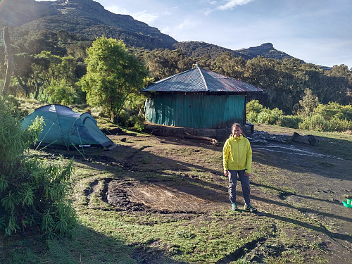 Image #2: My daughter in front of our tent and the kitchen hut at Chennek.