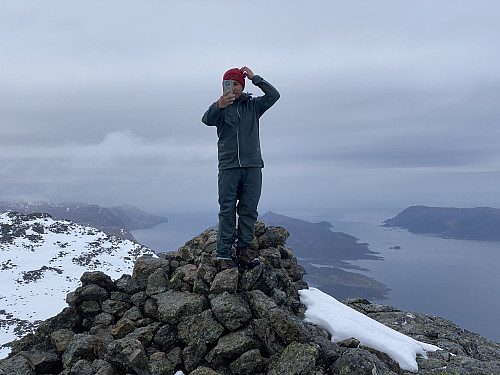 Image #15: Capturing a selfie while on the summit of Mount Hornelen. View towards the island of Husevågøy, between the fjords of Vågsfjorden and Fåfjorden.