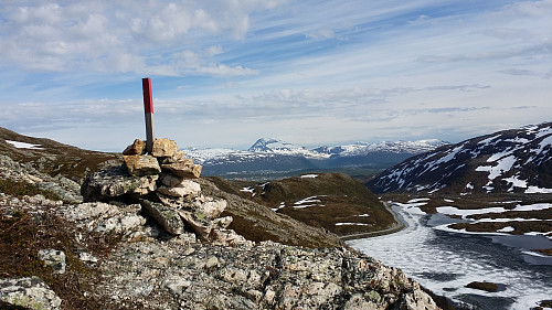 Liten varde på tur opp med utsikt over Finnvikvatnet til høyre og Tromsdalstinden fjernt i bakgrunn.