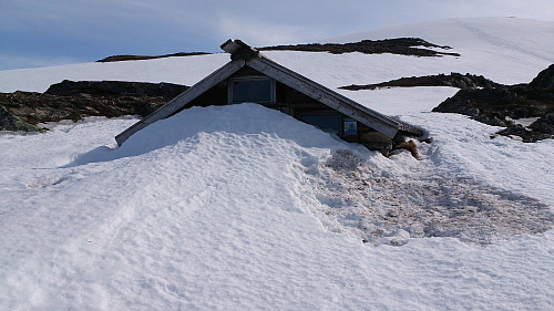 Steinbøhytta dekket av snø.