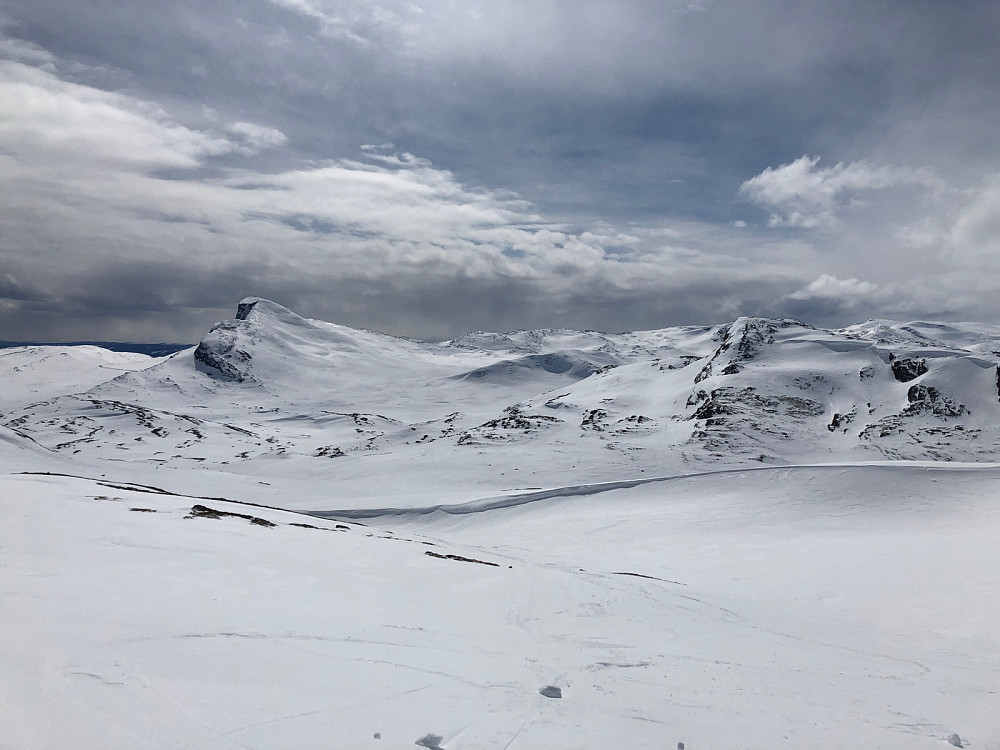 Utsikt til Bitihorn til venstre og Mefjellet til høyre i bildet. ADVARSEL Legg merke til skavlene til høyre/nord for Mefjellet, kjøring ned her forutsetter god kjennskap til fornuftig veivalg og aktuelle snøforhold.