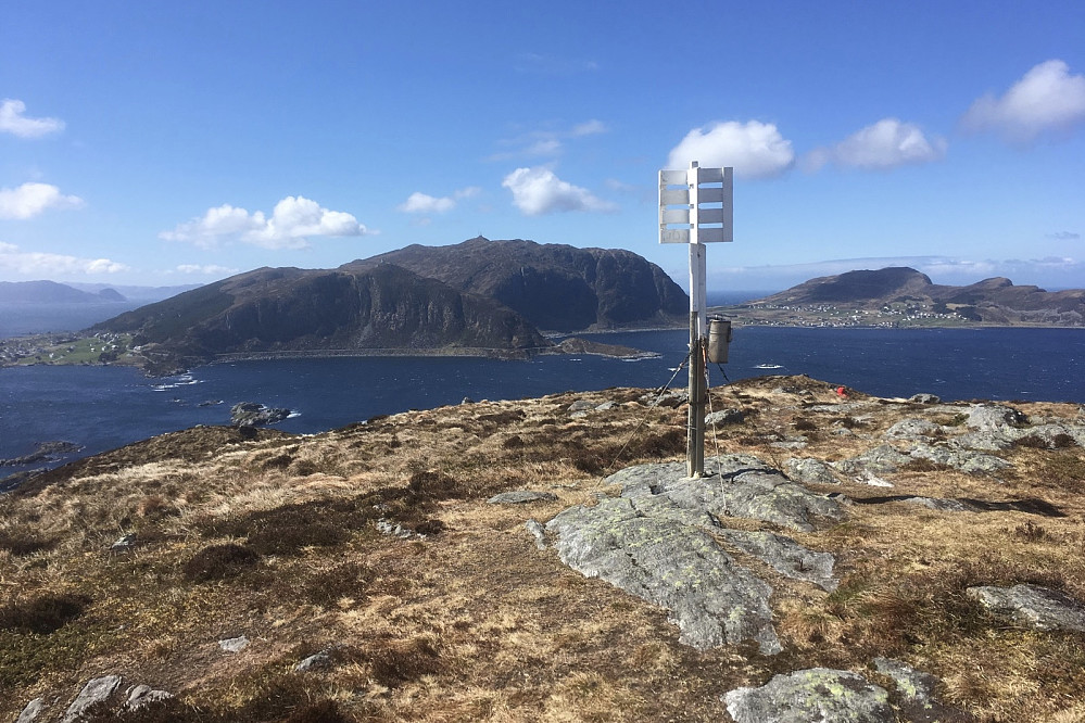 Trig-merket med Nerlandsøya i bakgrunnen. Astrid har søkt ly for vinden nede i en grop!