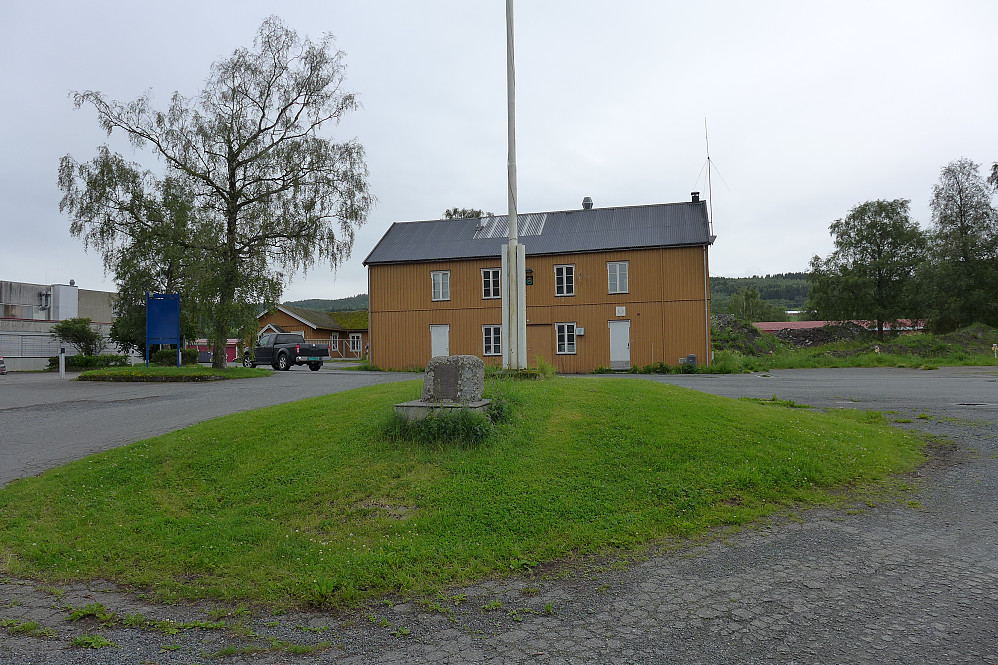 Flaggstangen i Rinnleiret. Det var nære på at Kartverkets granittsøyle ble flyttet hit foran flaggstangen da de var på leting etter en stor stein som skulle ligge foran flaggstangen! Heldigvis ble det ikke noe av dette!