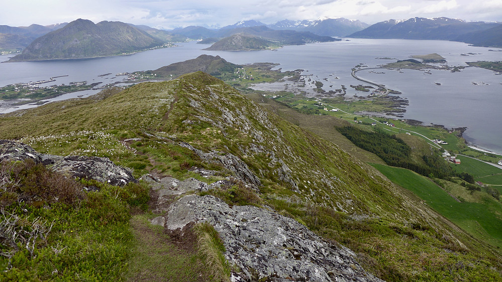 Stien går langs søryggen av fjellet med flott utsikt ned mot gårdene på sørsiden av Sandsøya og mot veien som slynger seg flott mot den lille øyen Voksa der det er fergeanløp