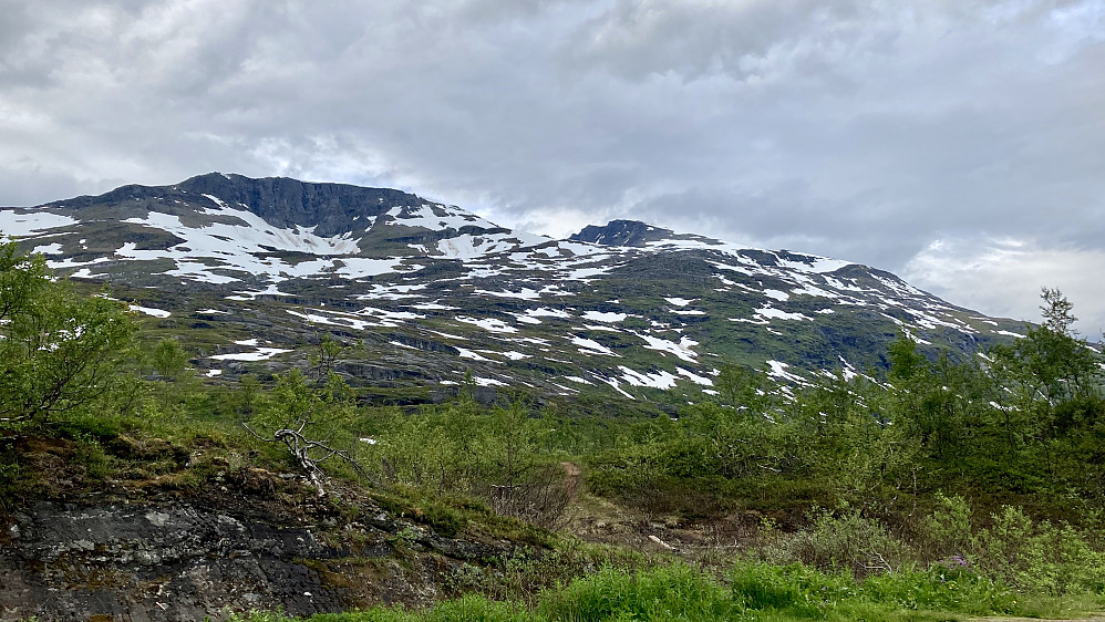 På dette bildet tatt fra p-plassen ser en Sølvfjellet 1290 til venstre og den tilsynelatende lavere Spanstinden 1457 med taggene litt til høyre for midten.