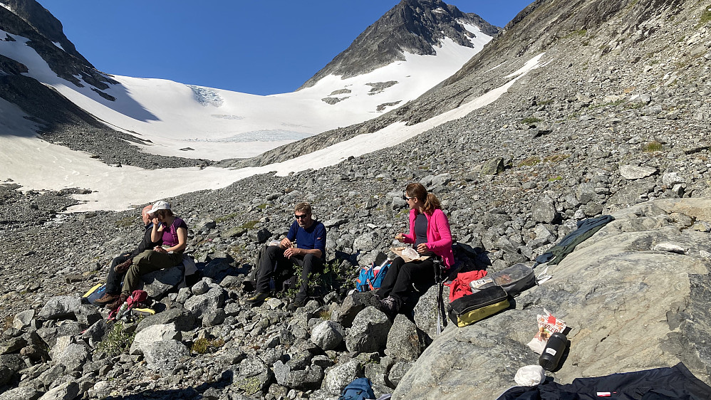 Matpause i solen før vi går inn på breen. Veslefjelltinden i bakgrunnen mot høyre. Vi skal opp breen til venstre for brefallet