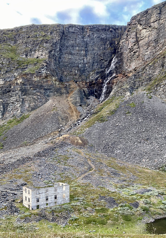 Reminisenser etter kopperutvinning høyt oppe i Kåfjordalen. Til venstre for fossen sees to gruveganger som munner rett ut i den bratte fjellsiden.