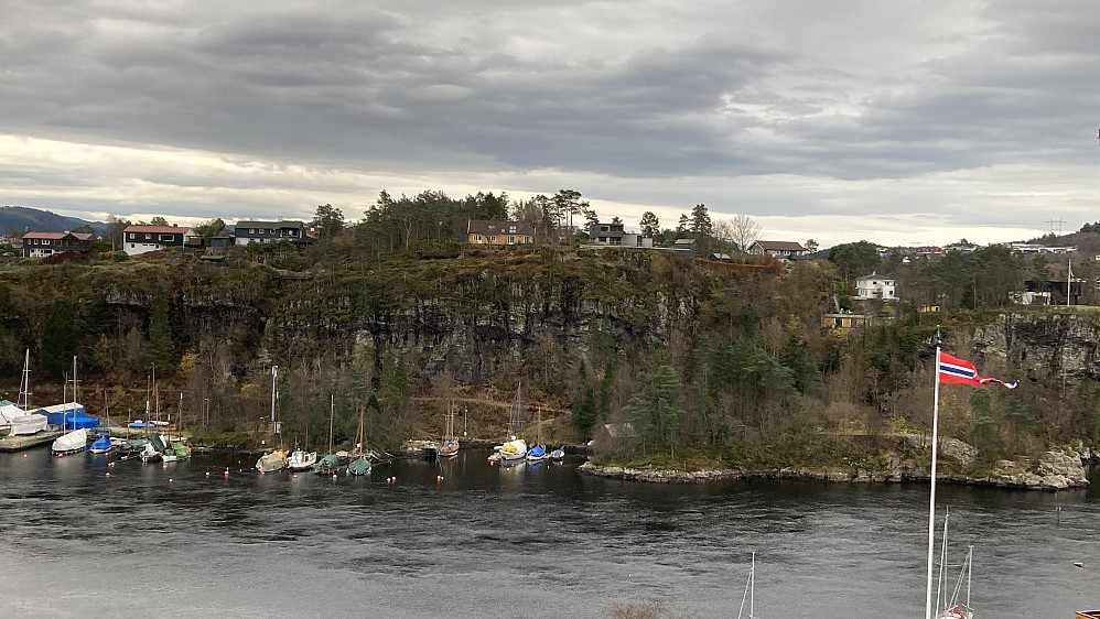 Ruskeneshaugen sett fra Knappenveien i nord. "Toppen" ligger inne i skogholtet til venstre for det gule huset.