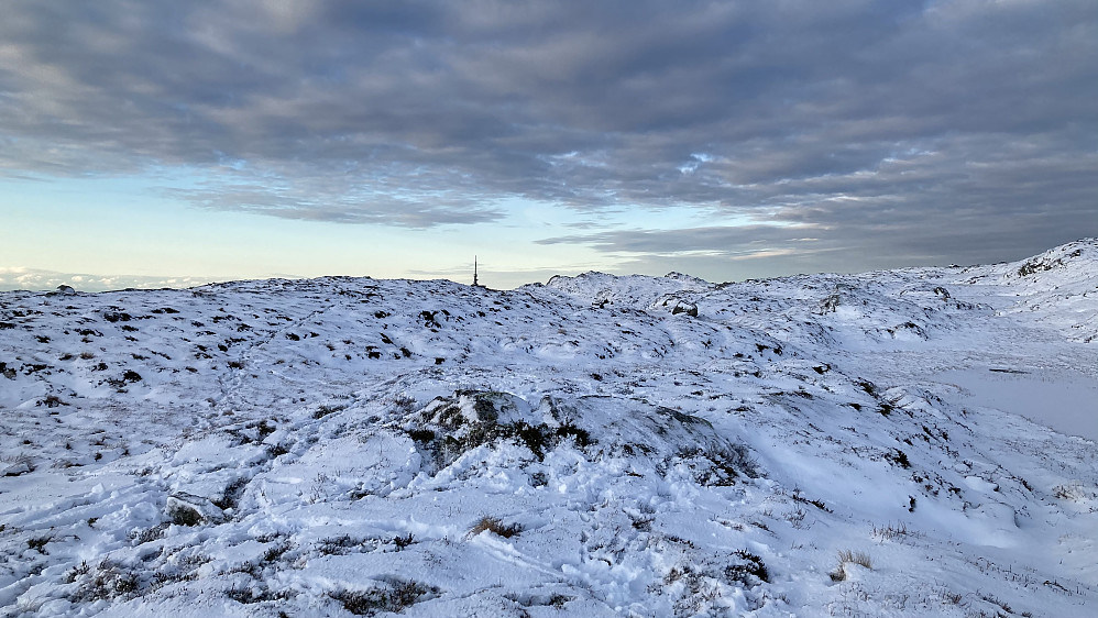 Tuft etter Solhaug med Ulriksmasten i bakgrunnen. Gjenværende steiner fra grunnmuren antagelig dekket av snø.