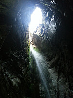 Fasinerende innerst inne i grotta der vannet fosser inn med dagslyset..