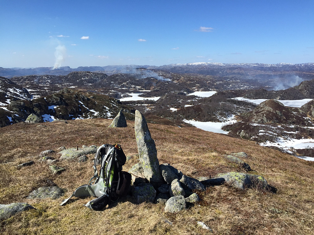 Utsikten fra høyeste toppen i Flekkefjord med flere gress og lyngbranner i fjellene rundt
