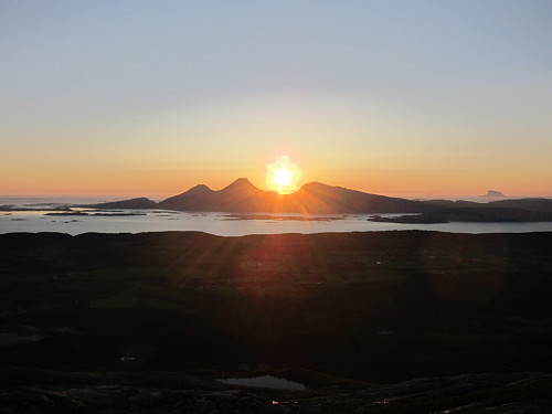 Solnedgang bak Dønnamannen. Lovund ligger bak til høyre.