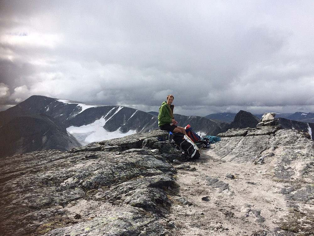 Jan Petter koster på seg en matbit ved varden på Larstinden. Nå er det bare en 2k-topp som mangler på Dovre! Svånåtindan og Store Langvasstind i bakgrunnen.