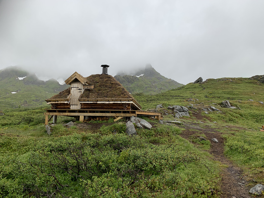 Åpen kvilebu med ildsted og benkeplass til et middels stort turfølge.