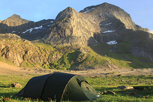Midnattsolen skinner på teltet og fjellene ved Bunes strand.
