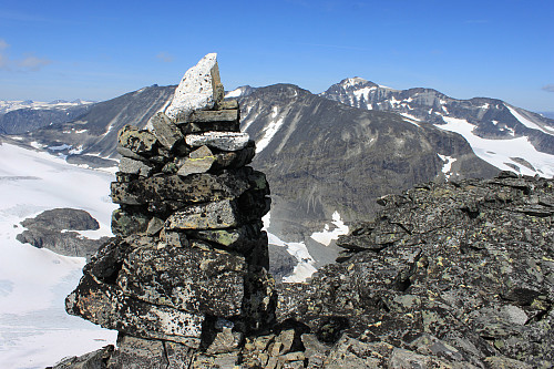 Varden på toppen av Styggehøe (2213 m). I bakgrunnen Tverråtindan og Galdhøpiggen.