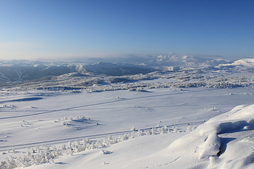 Vinter på toppen av Nørre Knausehøgdi med utsikt vestover mot Raudalen Alpinsenter, Slettefjell, Raudhorn og Mugnetinden. I forgrunnen ses skiløypene over Garlimyrane.