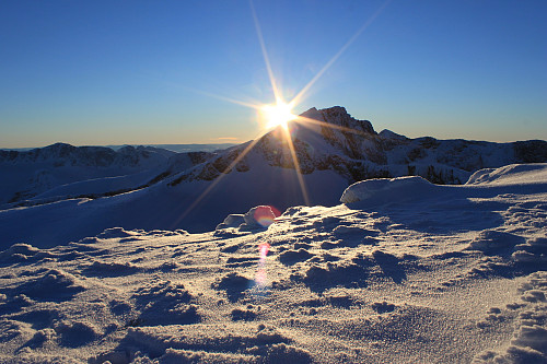 Solen går ned omtrent ved Tjønnholstinden (2330 m.o.h.).