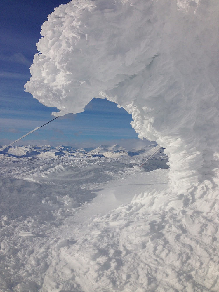 Nedsnødd hytte på toppen av Bitihorn (1607 moh). Jotunheimen i bakgrunnen.