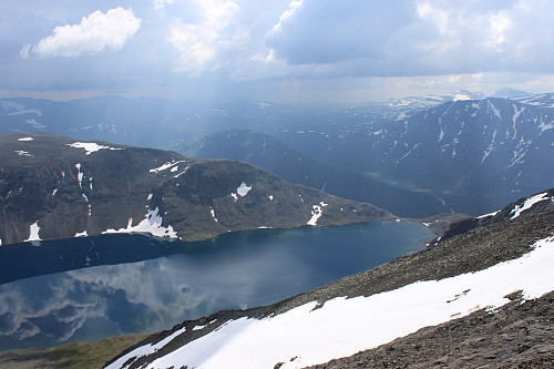 Bessvatnet og Besseggen langt der nede fra oppstigningen til Besshøe (2258 moh.). Truende tordenvær nærmer seg fra Valdresflya...