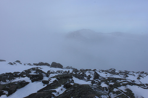 Tåke på toppen av Rasletinden (2105 moh). Tjønnholstinden (2330 moh) og Høgdebrotet (2226 moh) sees så vidt bak tåkeskyene.