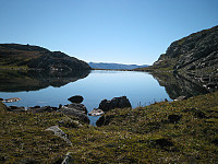 Tjern (1427 m.o.h.) mellom Synshorn og Heimre Fagerdalshøe. Mugnetinden (1737 m.o.h.) ses i bakgrunnen.