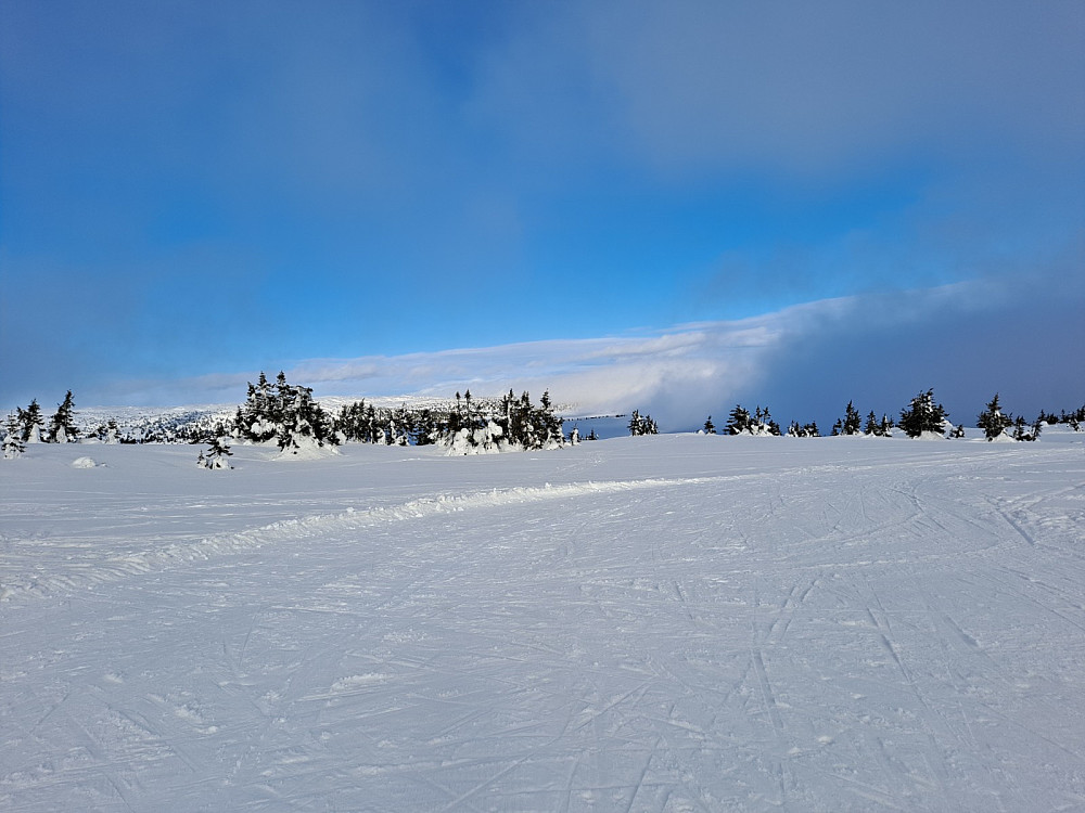 Øverst i løypa nord for Nevelvatnet, sol på Reinsfjellet, tåkedriv på Kriksfjellet